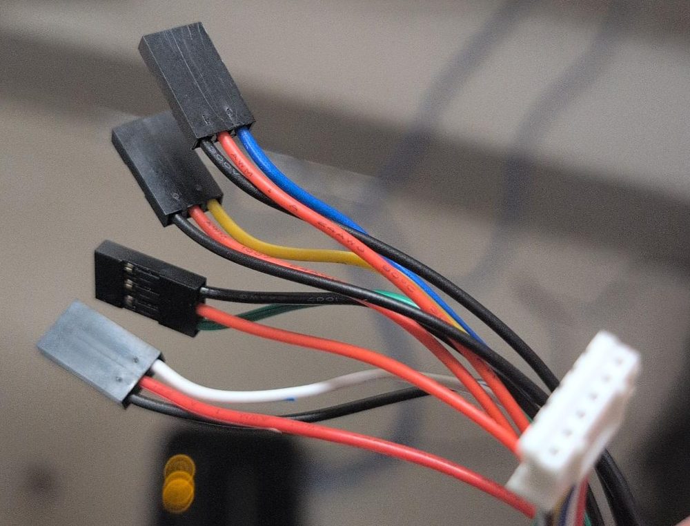 The Through Bore Encoder's cable: a white 6-pin JST plug at one end, and four black 3-pin Dupont plugs with blue, yellow, green, and white signal wires